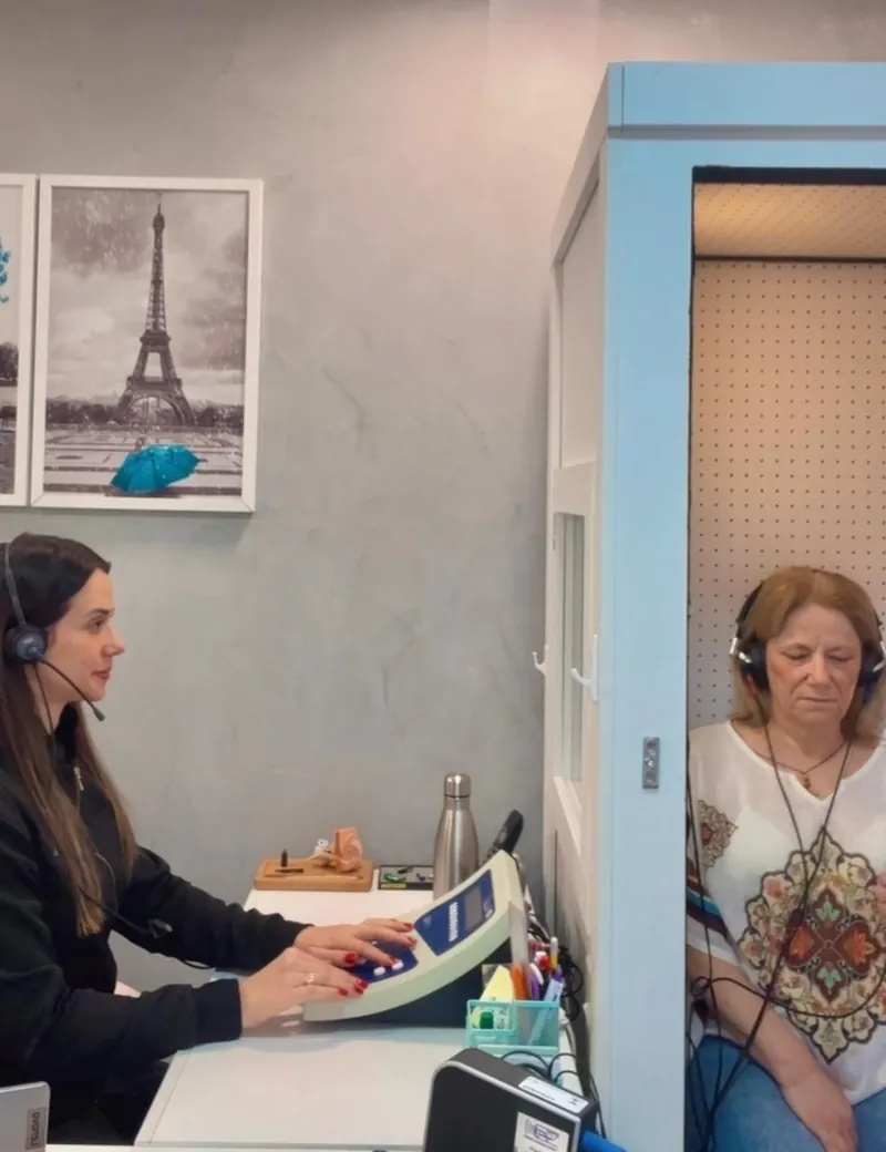 Dra. Priscila realizando audiometria com a paciente na cabine acústica